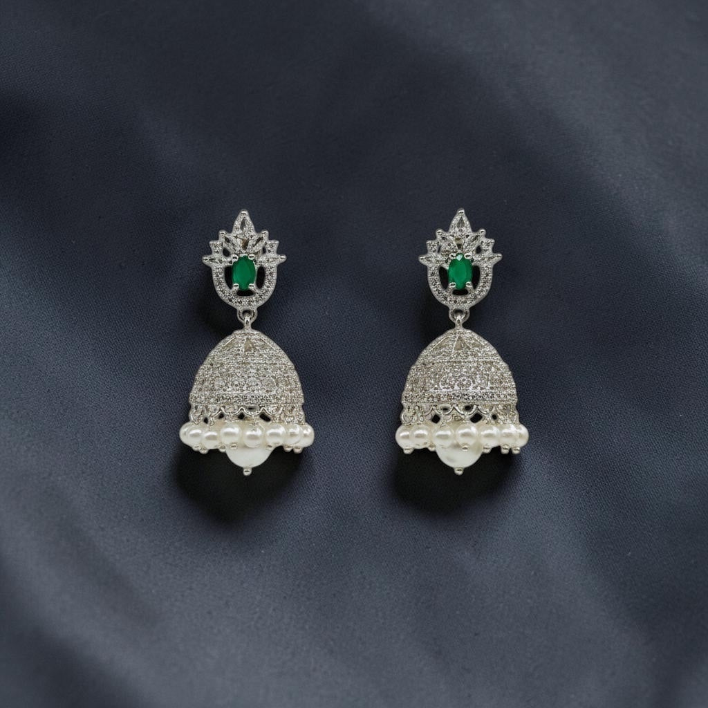 Lakx Fashion rhodium-tone brass jhumka earrings with green oval stones, white CZ accents, and dangling white pearls.