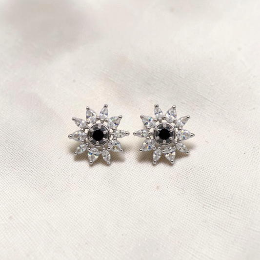 Lakx Fashion silver-tone starburst stud earrings with black central stones and clear marquise-cut cubic zirconia petals.