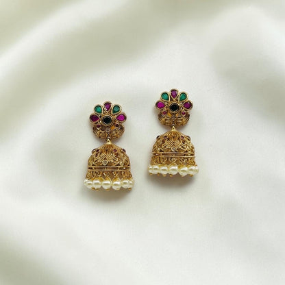 Lakx Fashion gold-tone brass jhumka earrings with floral studs, green and ruby stones, and dangling white pearls.