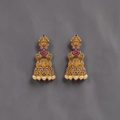 Lakx Fashion gold-tone brass jhumka earrings with temple motifs, red and green stones, and dangling pearl beads.