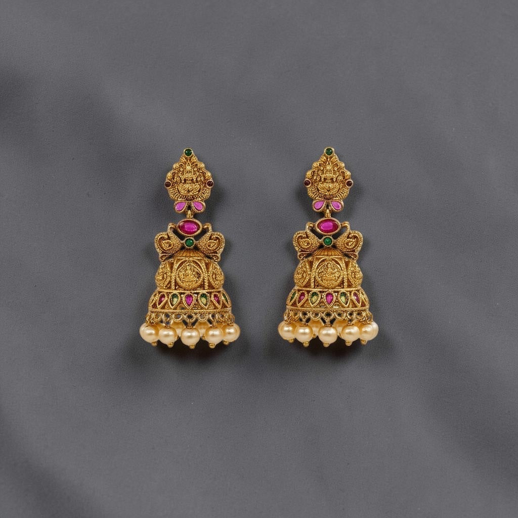 Lakx Fashion gold-tone brass jhumka earrings with temple design, red and green stones, and dangling yellow pearls.