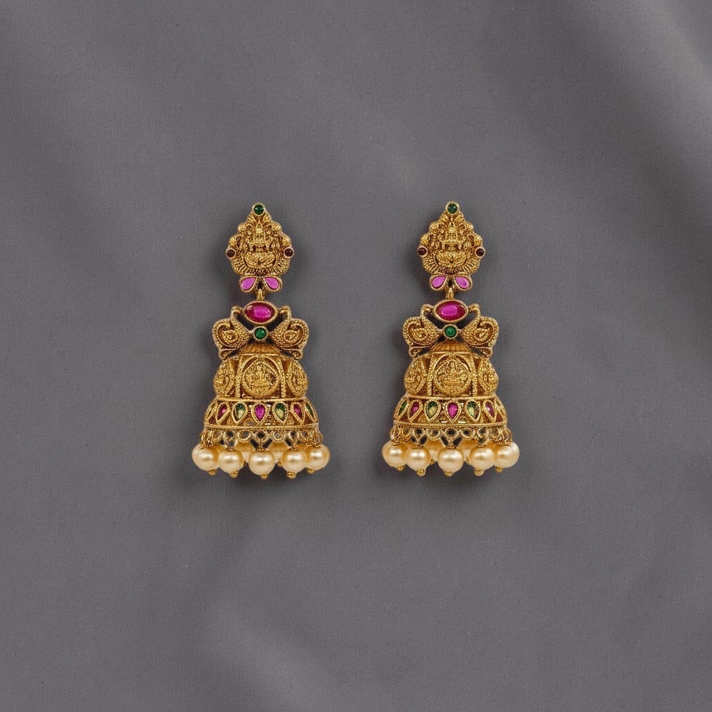 Lakx Fashion gold-tone brass jhumka earrings with temple motifs, red and green stones, and dangling yellow pearls.