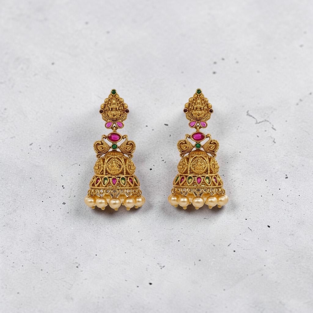 Lakx Fashion gold-tone brass jhumka earrings with temple design, colorful stones, and dangling yellow pearls.