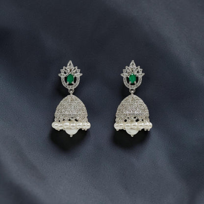 Lakx Fashion rhodium-tone brass jhumka earrings with green oval stones, white CZ accents, and dangling white pearls.