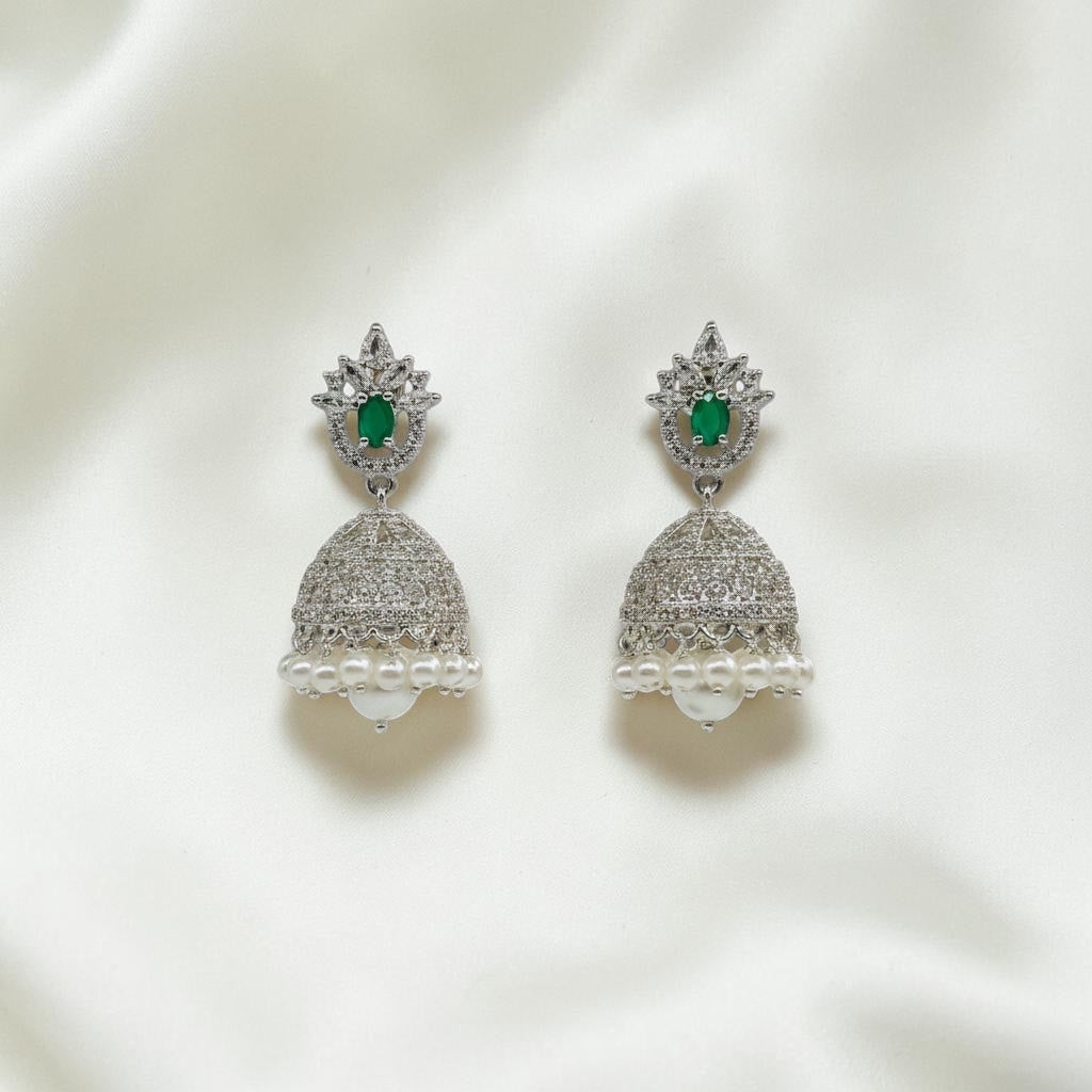 Lakx Fashion rhodium-tone brass jhumka earrings with green oval stones, white CZ accents, and dangling white pearls.
