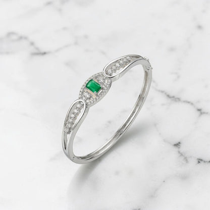 Lakx Fashion hinged brass kada bracelet with a central emerald-cut green stone and pavé-set clear stones.