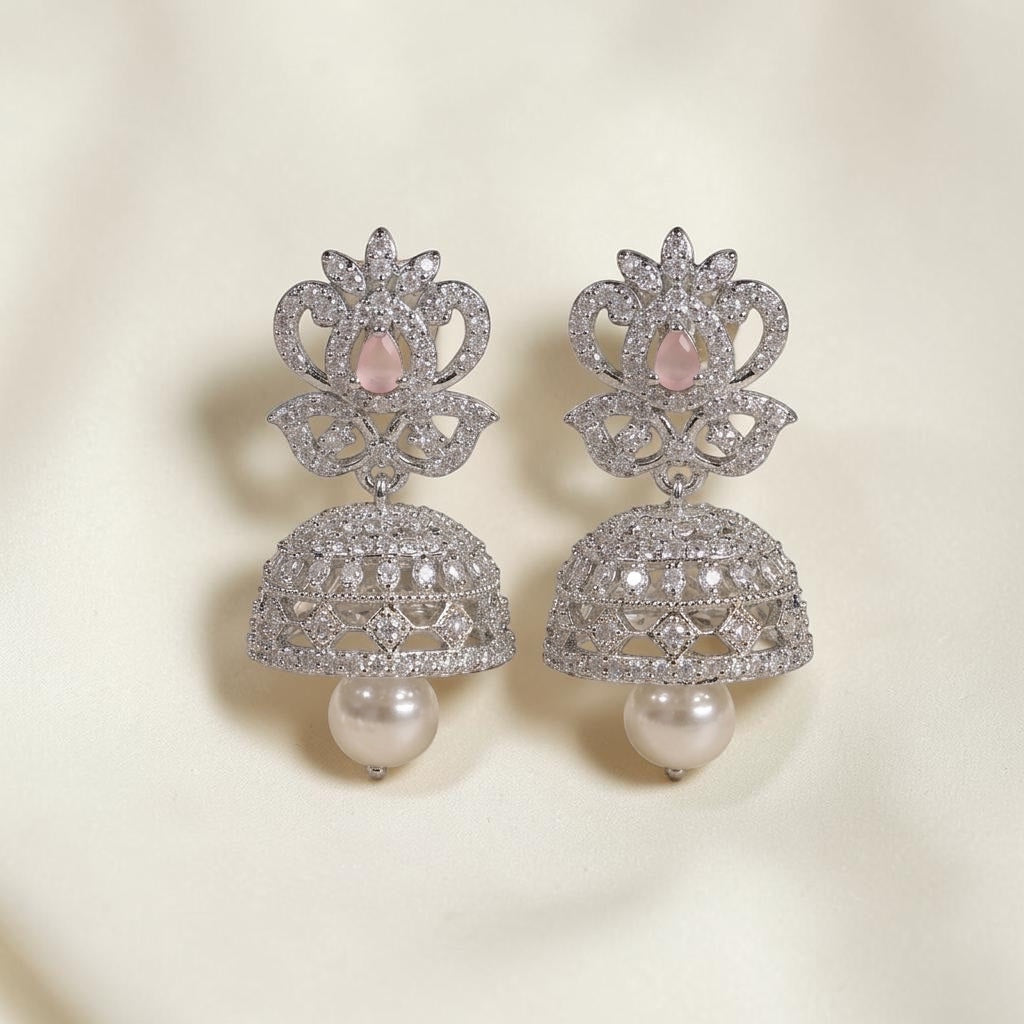 Lakx Fashion rhodium-tone brass jhumka earrings with pink oval stones, white CZ accents, and hanging pearl drops.