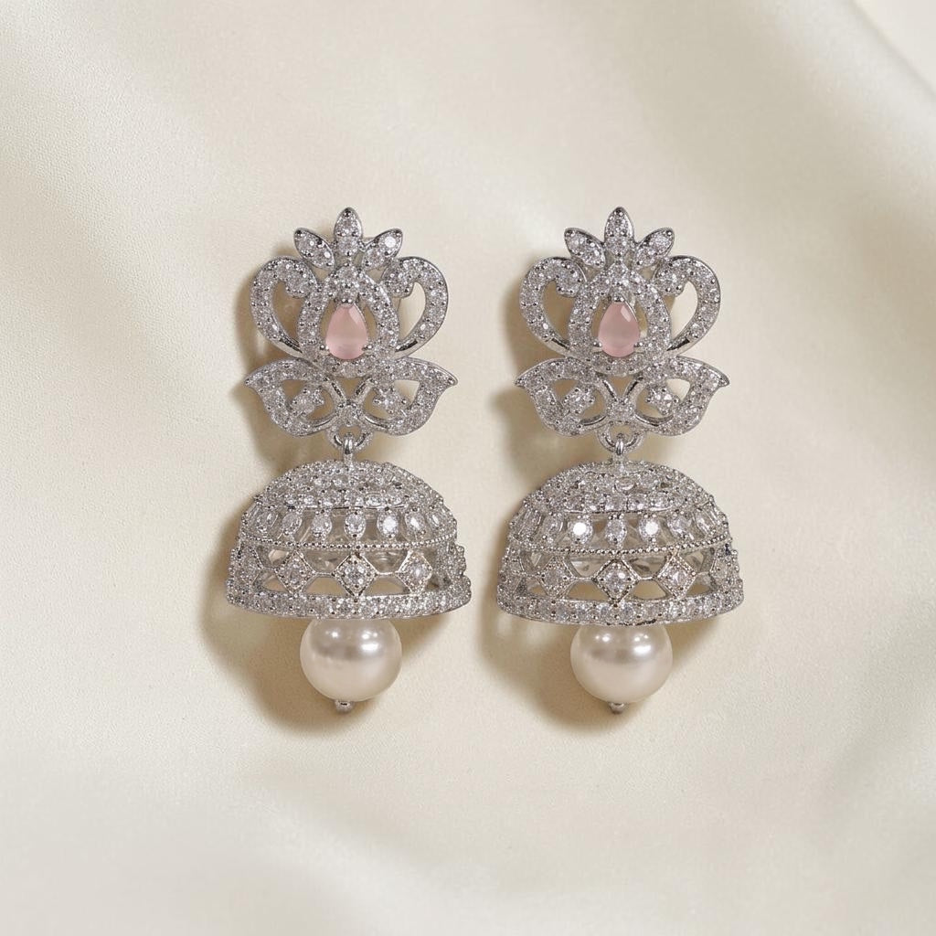 Lakx Fashion rhodium-tone brass jhumka earrings with pink oval stones, white CZ accents, and hanging pearl drops.