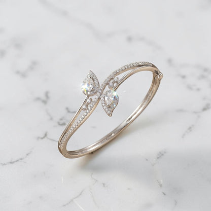 Lakx Fashion rhodium-tone brass openable bracelet with pear-shaped white CZ stones and pavé accents on a marble surface