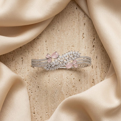 Lakx Fashion rhodium-tone brass bracelet with pink marquise stones and white CZ leaf-like clusters on satin fabric.