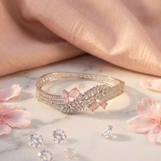 Lakx Fashion rhodium-tone brass bracelet with pink marquise stones and white CZ leaf accents on a marble surface.