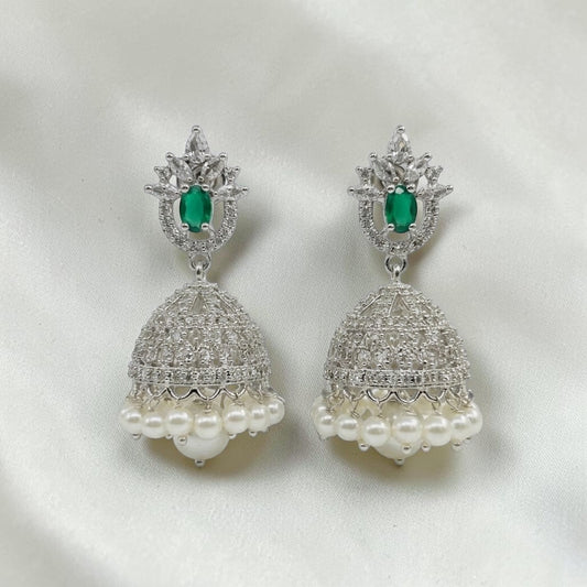 Lakx Fashion rhodium-tone jhumka earrings with green teardrop stones, white CZ, and pearl drops on a white fabric.