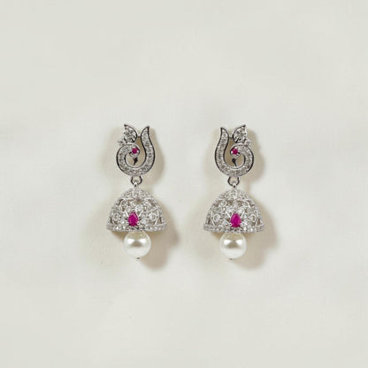 Lakx Fashion rhodium-tone jhumka earrings with peacock motif, ruby-colored stones, white CZ, and pearl drops.
