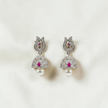 Lakx Fashion rhodium-tone jhumka earrings with ruby-colored stones, white CZ, and pearl drops in a peacock design.