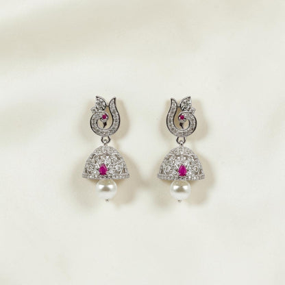 Lakx Fashion rhodium-tone jhumka earrings with peacock motifs, ruby-colored stones, white CZ, and pearl drops.